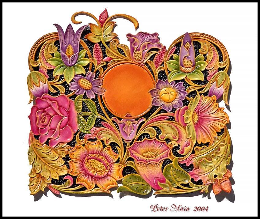 A dense leather carving of roses, tulips, daisies and scrolling leaves in pink, purple, gold and green around a plain orange centre.